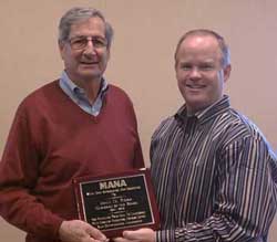 MANA Chairman of the Board Tom Hayward presents a plaque to John Roba (left)
